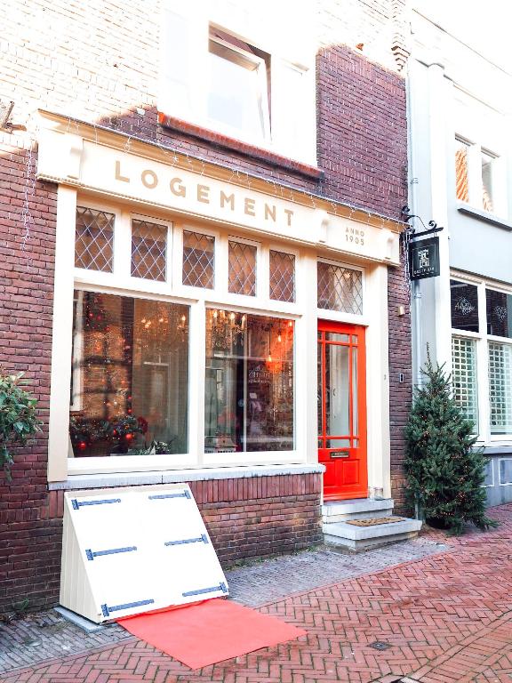 a store with a red sign in front of a building at B&B Tholen t’Uusje in Tholen