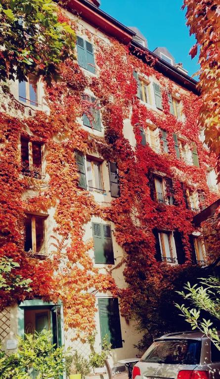 un edificio con hojas rojas a un lado. en Appart&#39;Hôtel Residence Dizerens, en Ginebra