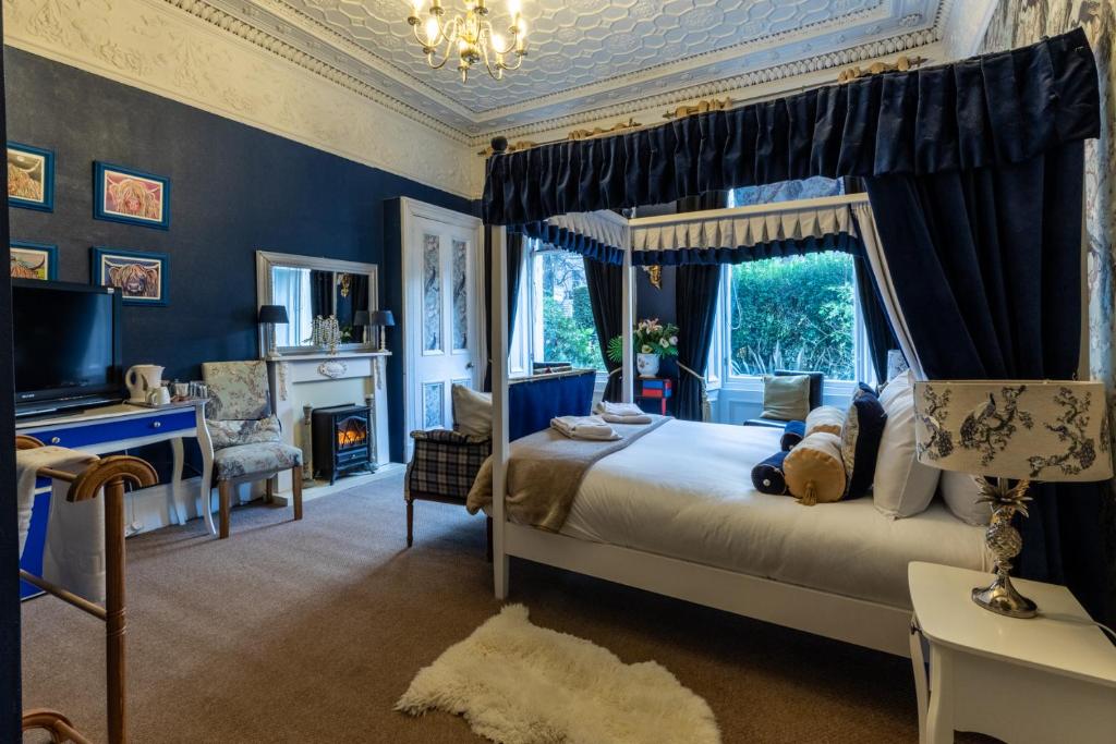 a bedroom with a bed and a desk and a television at East Claremont Guest House in Edinburgh