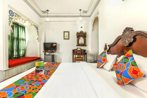 a bedroom with a large bed and a red couch at Hotel Pichola Haveli in Udaipur