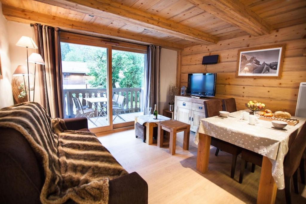 a living room with a table and a television in a cabin at Apartment Blaitiere - luxurious 2 bed apartment in Chamonix-Mont-Blanc
