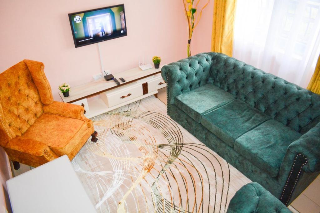 a living room with a couch and a tv at Fika Casa in Nakuru