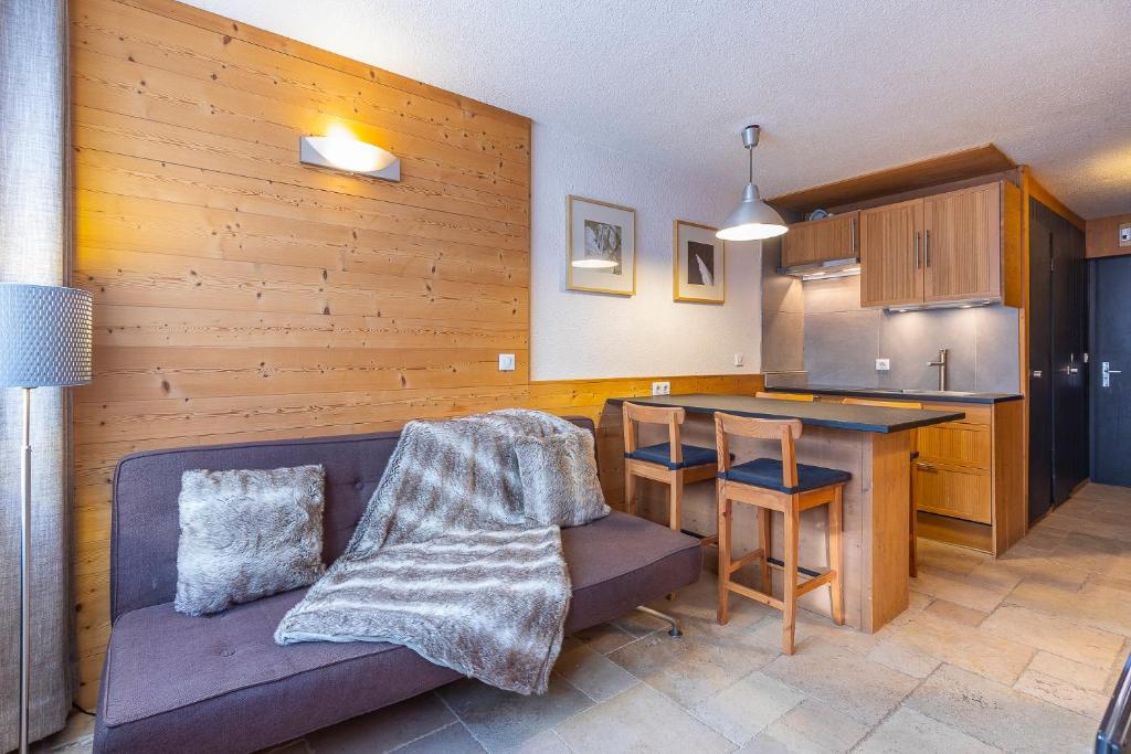 a living room with a couch and a kitchen at Val Thorens-Cosy Lauzières 315 in Val Thorens