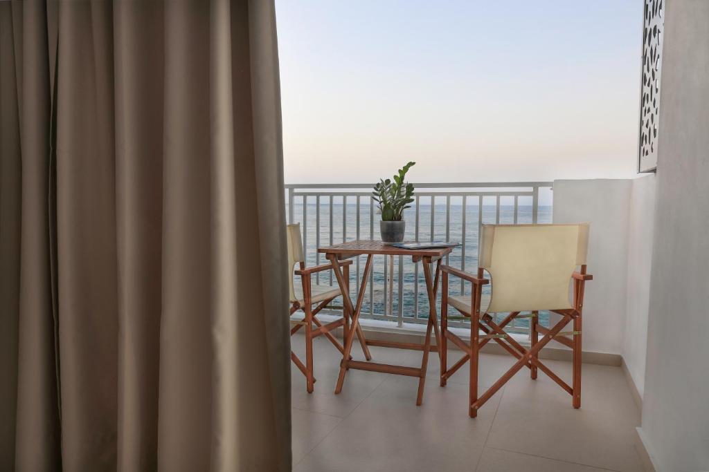 uma varanda com uma mesa e cadeiras. em Sea Breeze Hotel em Hersonissos