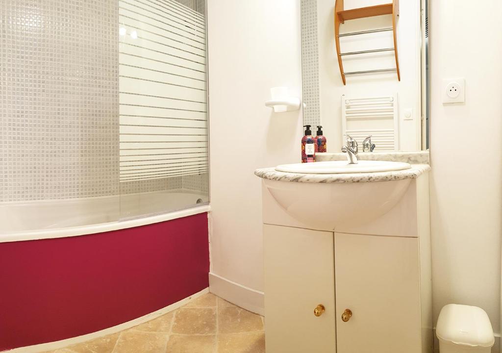 a bathroom with a sink and a bath tub at La Maison de Ville indépendante My Bastide Classée in Villefranche-de-Rouergue