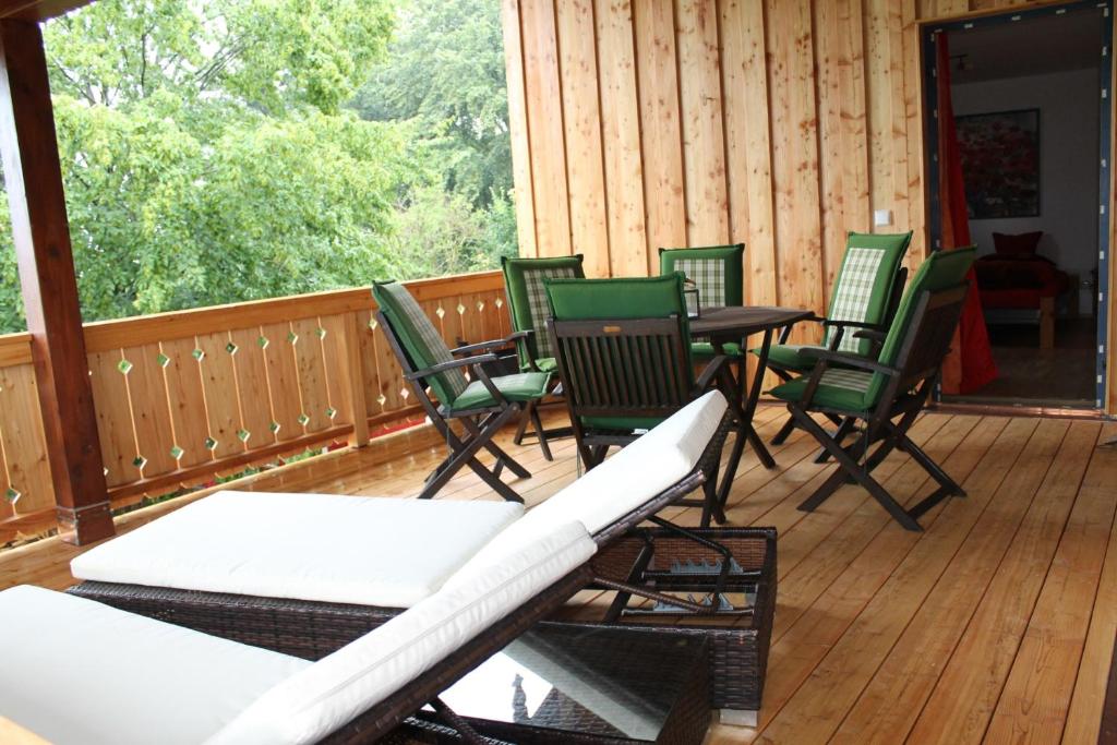 un groupe de chaises et de tables sur une terrasse dans l'établissement Ferienwohnung Sternschnuppe, à Chieming