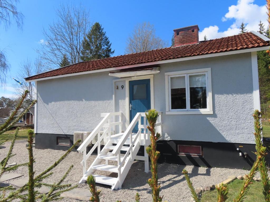 ein kleines weißes winziges Haus mit blauer Tür in der Unterkunft Vakantiehuis GWEN - vlakbij meer- van S&G Holiday in Nykroppa