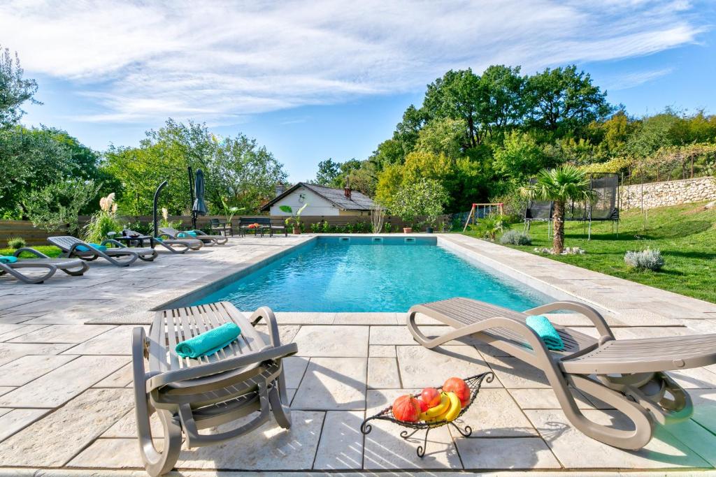 una piscina con dos sillas y una mesa en Villa Valentina, en Bribir