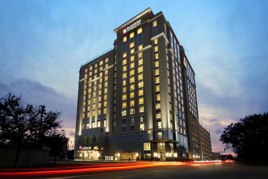 un edificio alto con luces encendidas por la noche en Blossom Hotel Houston, en Houston