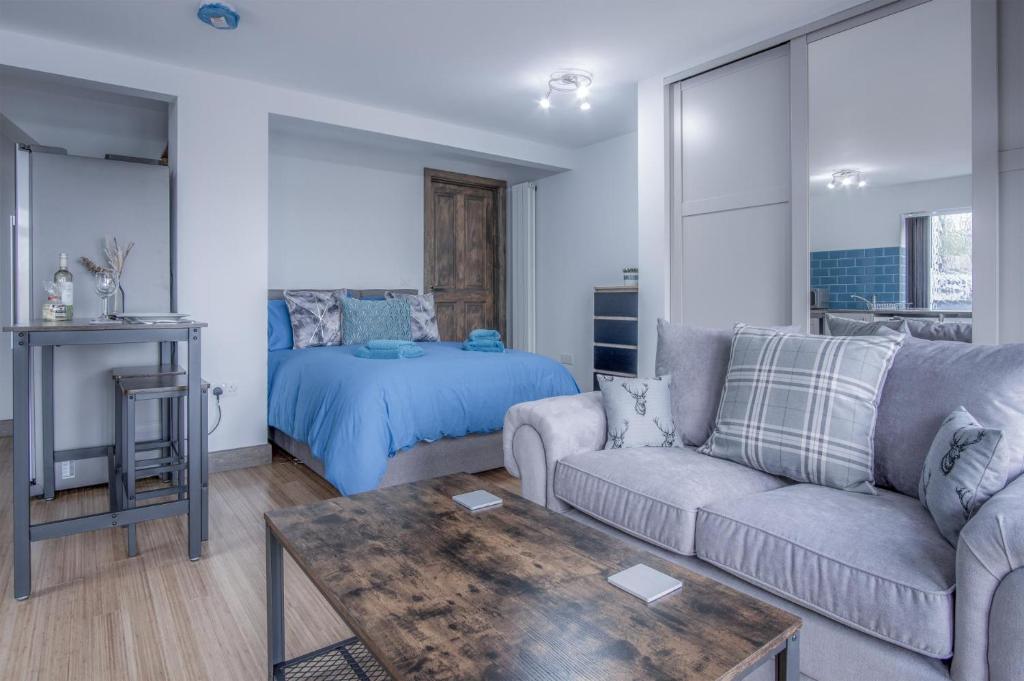 uma sala de estar com um sofá e uma cama em Haylands Hideaway - 1 Bedroom Apartment - Jameston em Manorbier