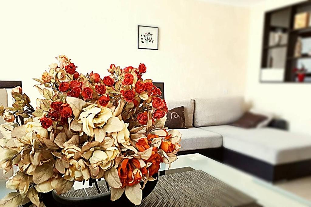 a vase of flowers sitting on a table in a living room at Apartment Lenina in Vitebsk