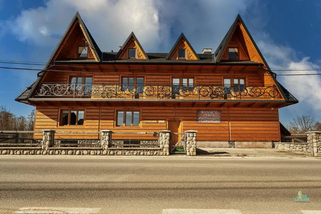 a wooden house on the side of the road at Pod Strumykiem in Czarny Dunajec