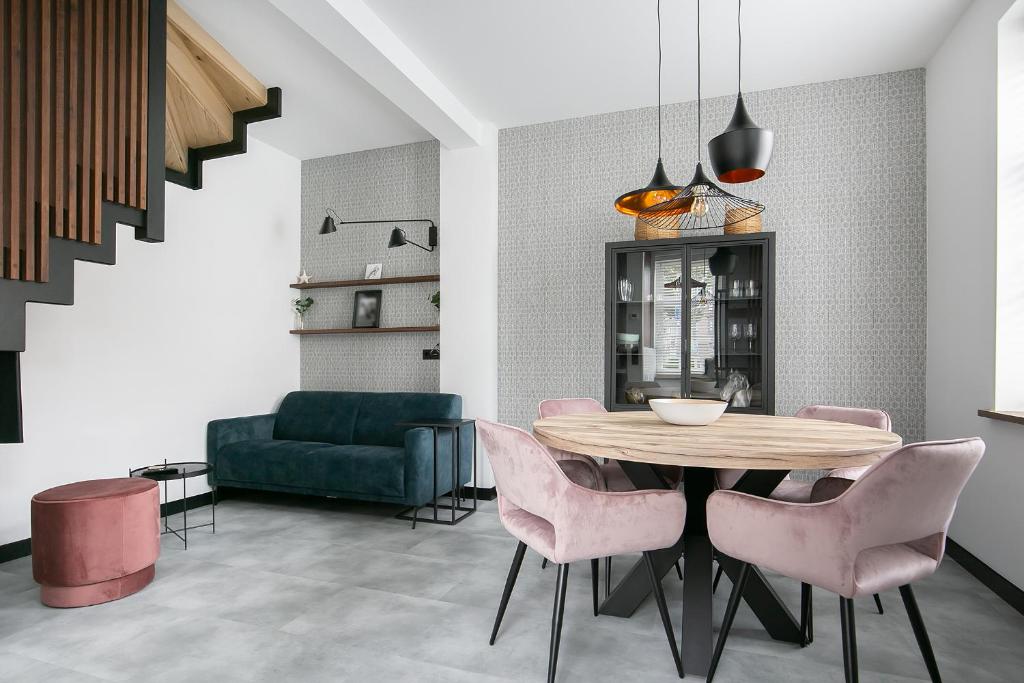 une salle à manger avec une table et des chaises roses dans l'établissement Hello Zeeland - Appartement Weststraat 36, à Domburg