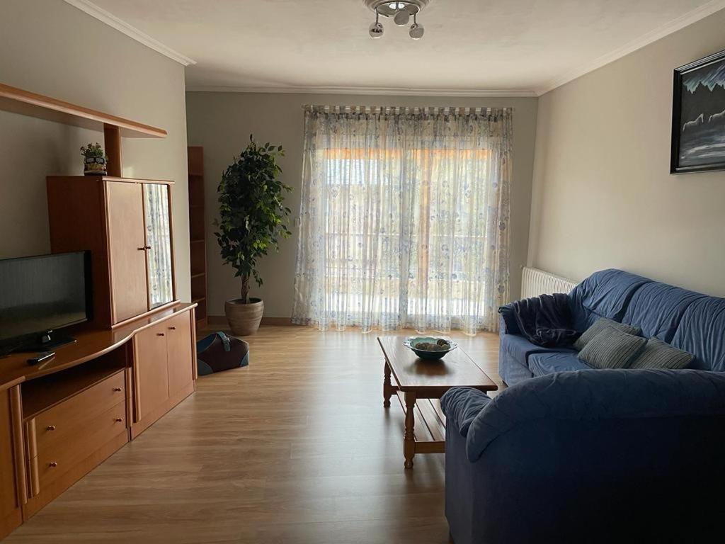 a living room with a blue couch and a table at A casa Daló in Folgoso