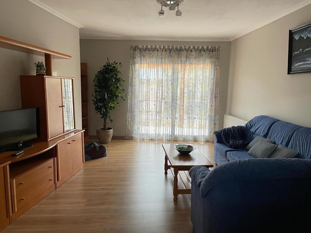 salon z niebieską kanapą i stołem w obiekcie A casa Daló I w mieście Folgoso