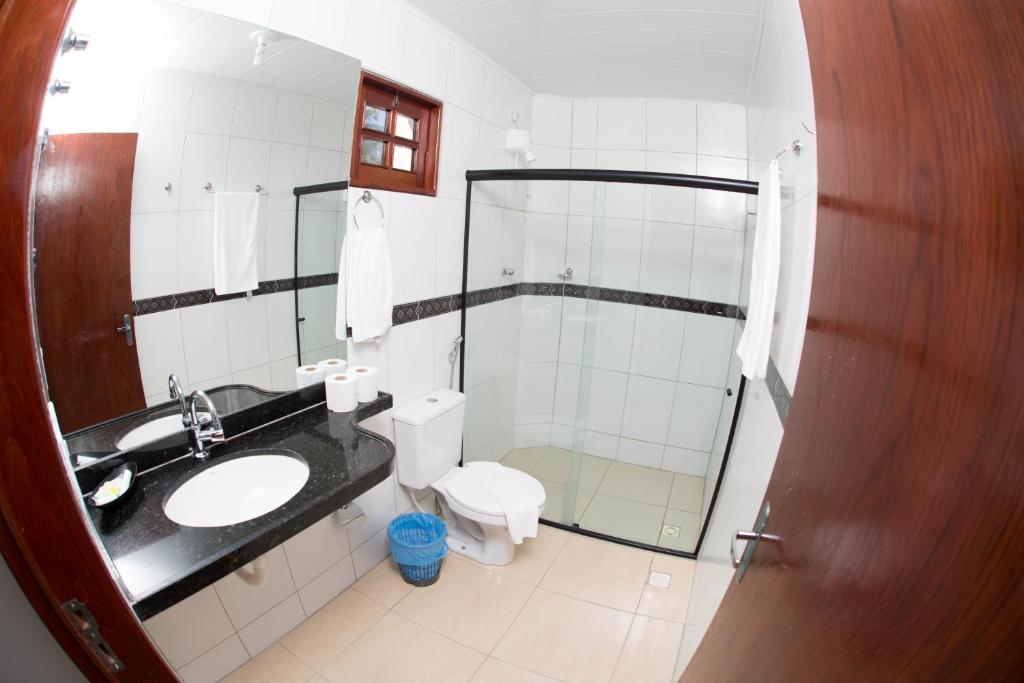a bathroom with a toilet and a sink and a shower at Pousada Recanto dos Milagres in São Miguel dos Milagres