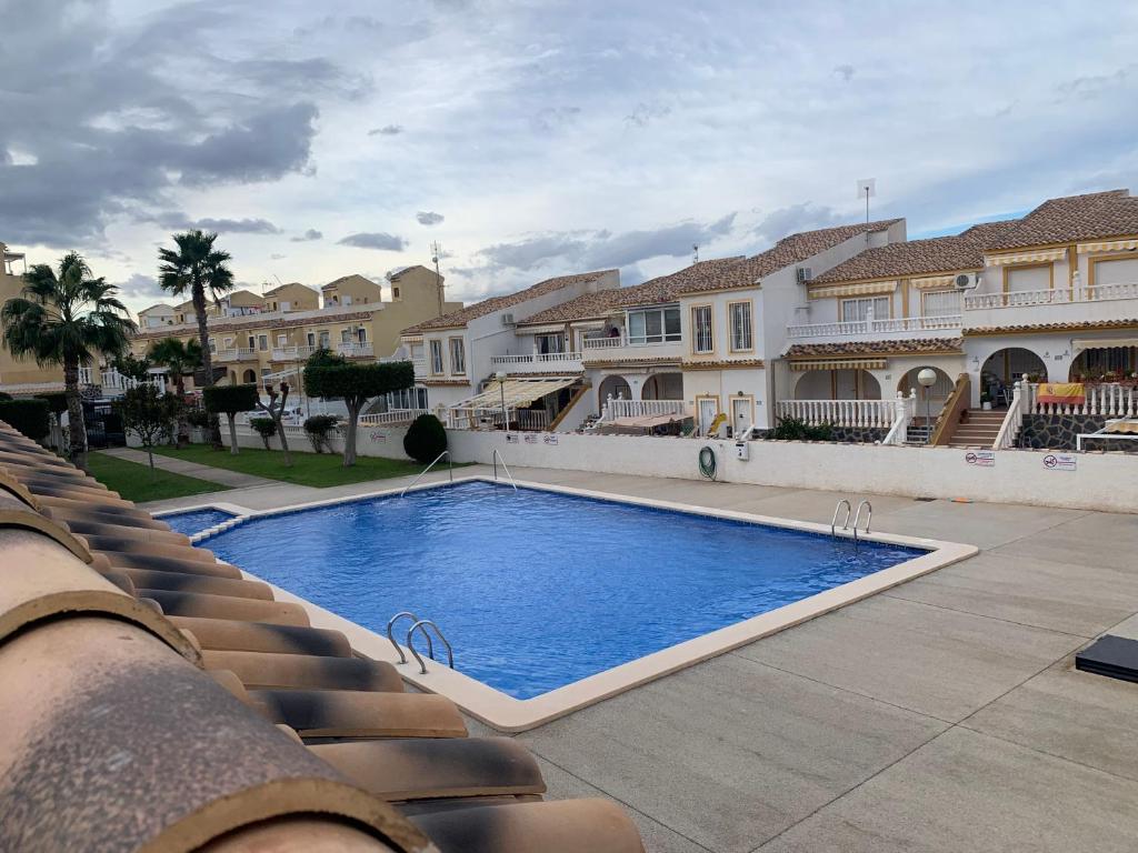 a large swimming pool in front of some houses at Adosado tranquilo con piscina y vistas al mar in Puerto Marino