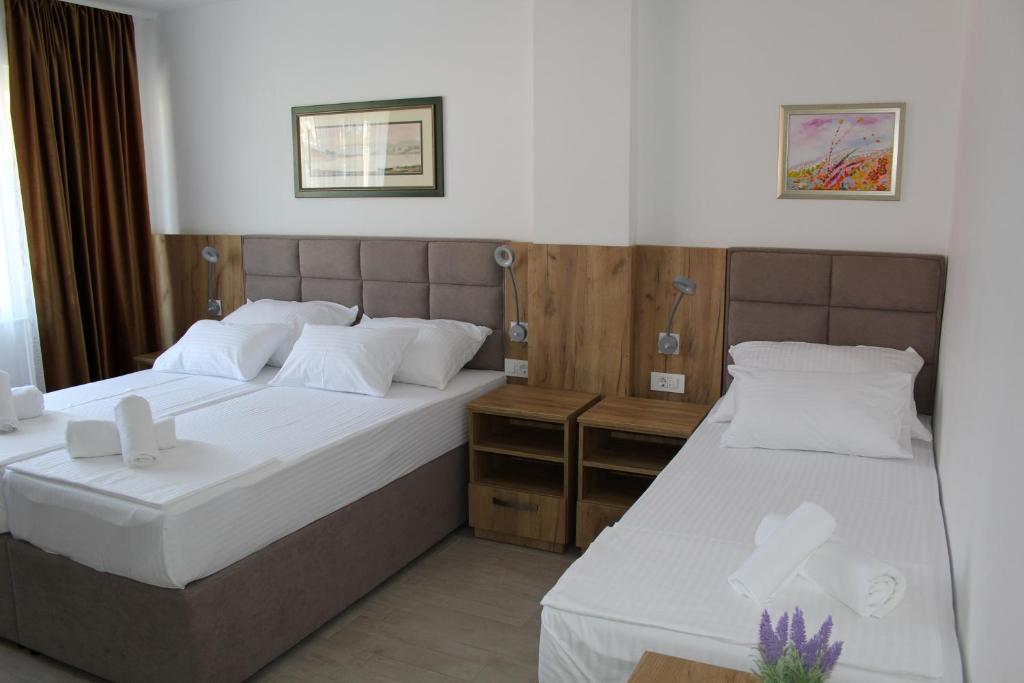 a bedroom with two beds with white sheets at Royal Apartmani in Banja Luka