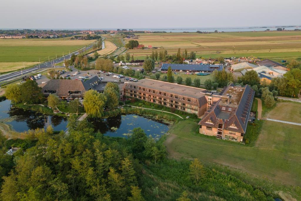 an aerial view of a building next to a river at Van der Valk Hotel Volendam in Volendam