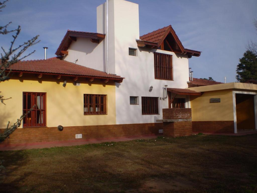 Casa blanca grande con ventanas y patio en Complejo Foxes 2 en Villa del Dique