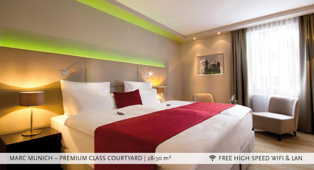 una camera d'albergo con un grande letto e una sedia di Marc München a Monaco