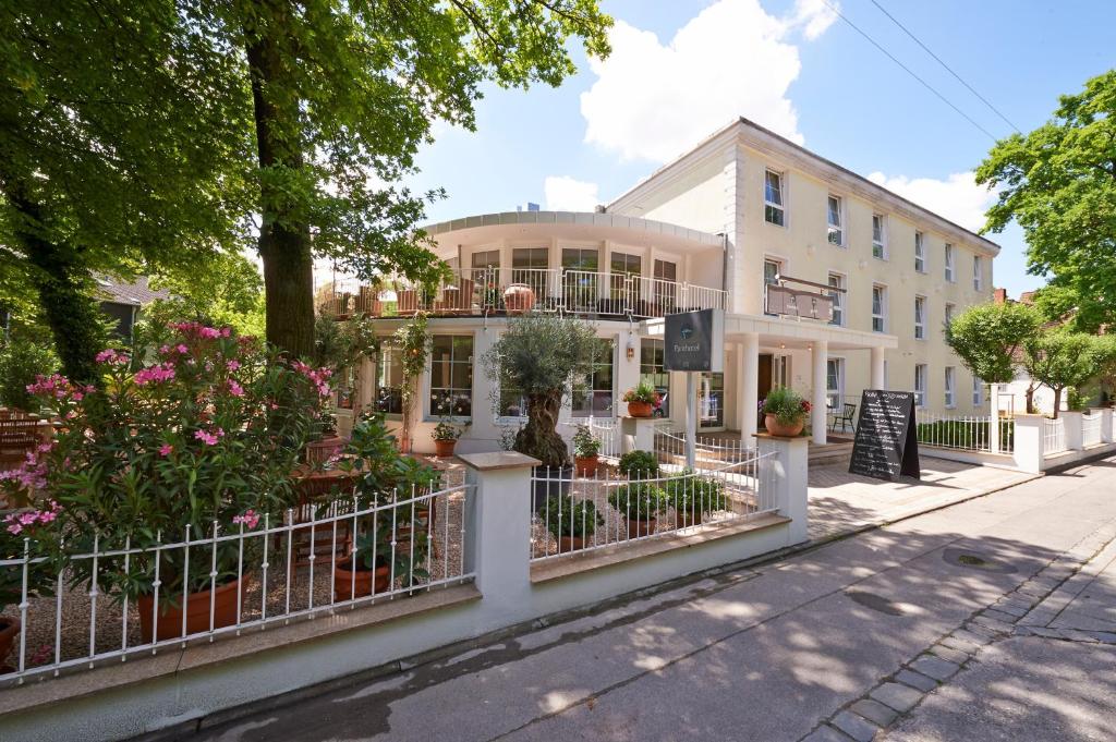 ein weißes Gebäude mit Blumen davor in der Unterkunft Parkhotel Obermenzing in München