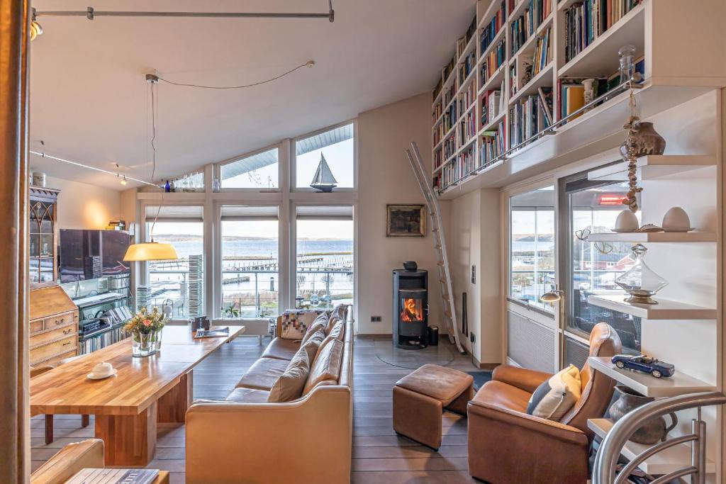 sala de estar con mesa, sillas y chimenea en fewo1846 - Residenz am Yachthafen - luxuriöses Strandhaus mit 2 Schlafzimmern, en Flensburg