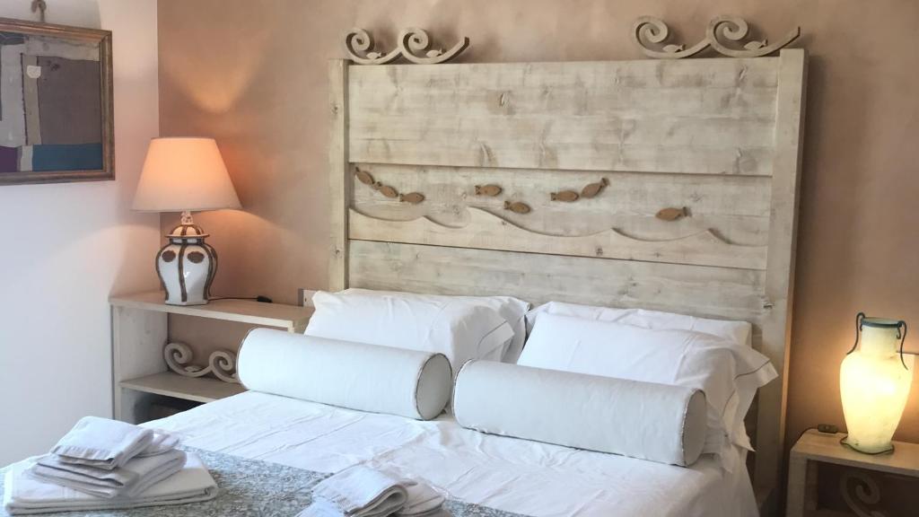 Cama blanca con almohadas blancas y cabecero en Colombella Apartment Agriturismo Collerisana, en Spoleto