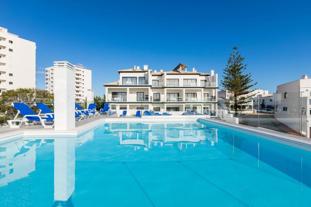 a swimming pool with a building in the background at Correeira Luxury Residence in Albufeira