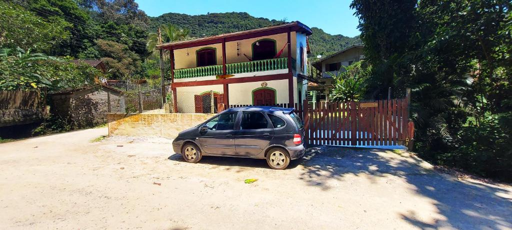 a small car parked in front of a house at Residencial Vitoria "Pé na Areia" in Ubatuba