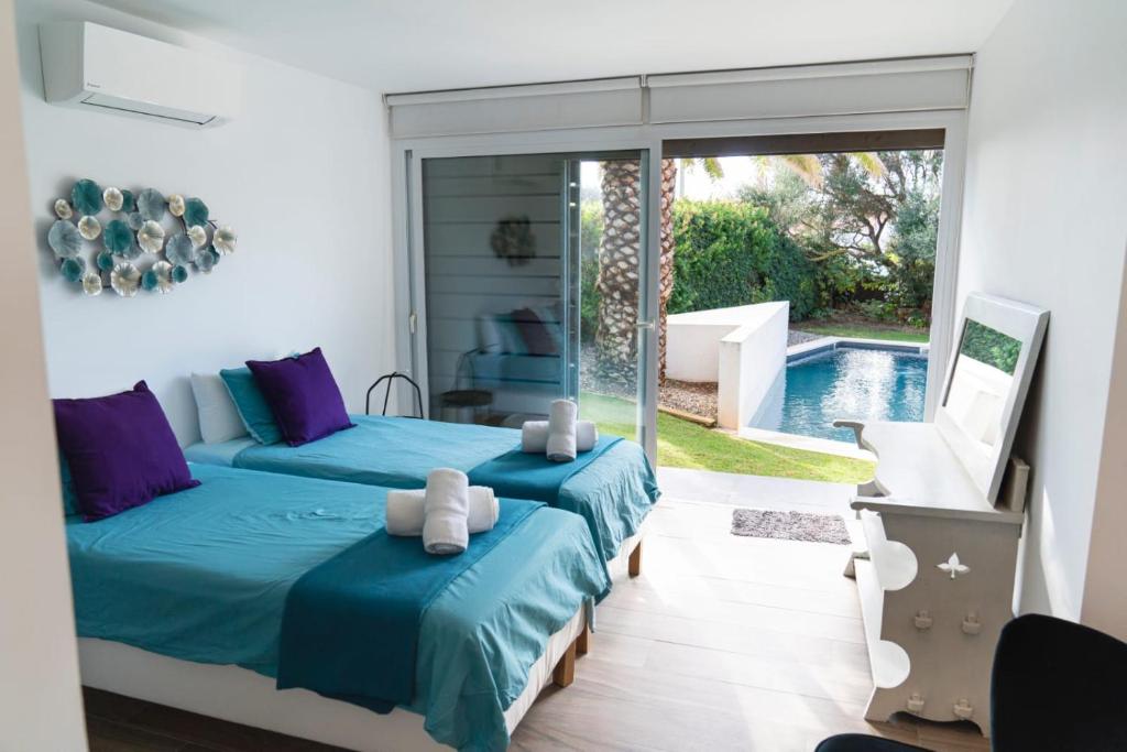 um quarto com 2 camas e uma piscina em VILLA LA PERLA BLANCA, YOUR DREAM IS TRUE em Binibeca