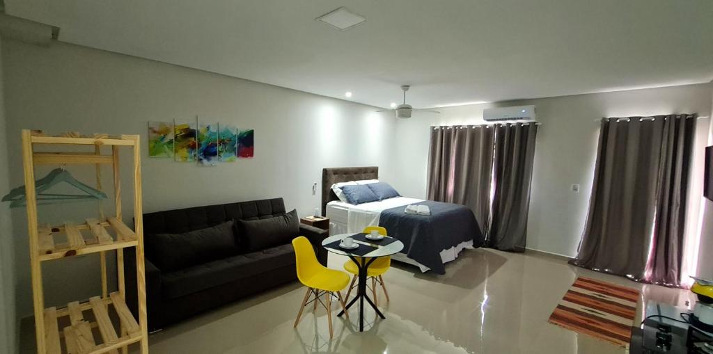 a living room with a bed and a couch at Residencial Oliveira - Charmoso e Aconchegante in Itacaré
