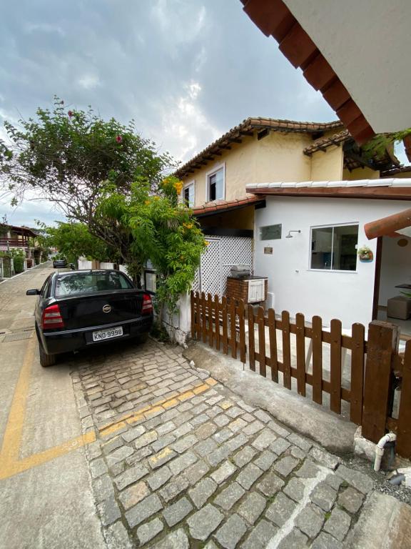 阿拉亚尔-杜卡布Suítes da Dri的停在房子前面的汽车