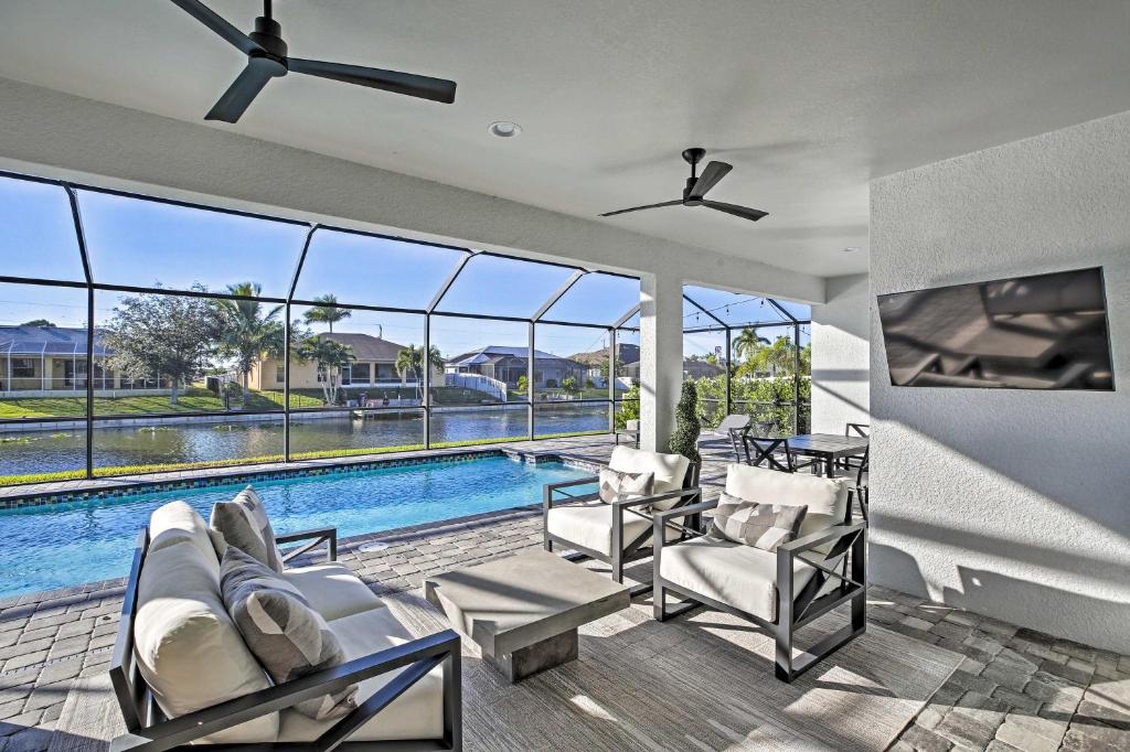 a living room with a pool and chairs and a ceiling fan at Sun-Seekers Getaway Lavish Cape Coral Villa in Cape Coral