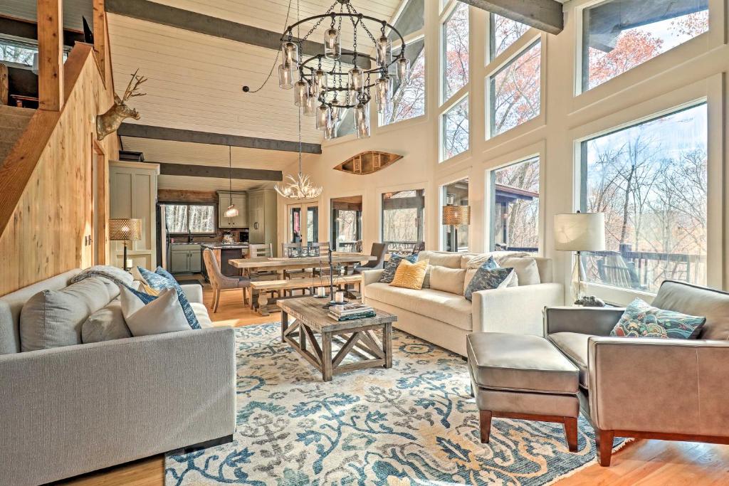 5 Mi to Ski Sapphire Valley Cozy Retreat with Decks في Sapphire: غرفة معيشة كبيرة فيها ثريا وطاولة