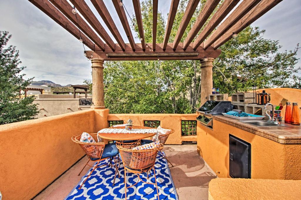 a patio with a table and chairs on a balcony at Adobe Escape with Outdoor Kitchen and Pool Access in Tubac