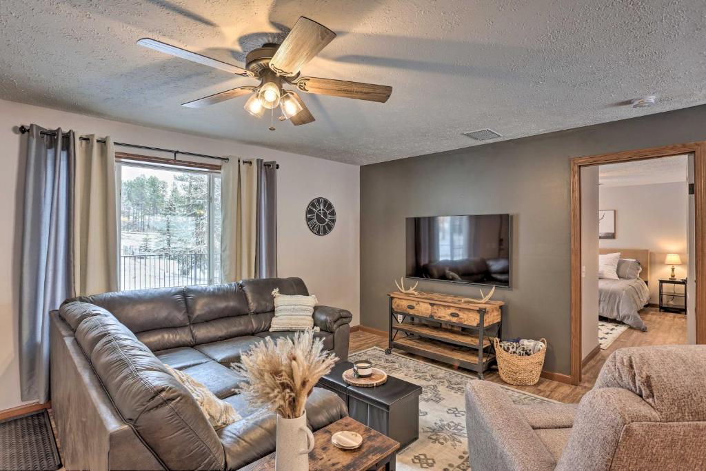 a living room with a leather couch and a television at 14 A Getaway Family House with Large Deck! in Sturgis