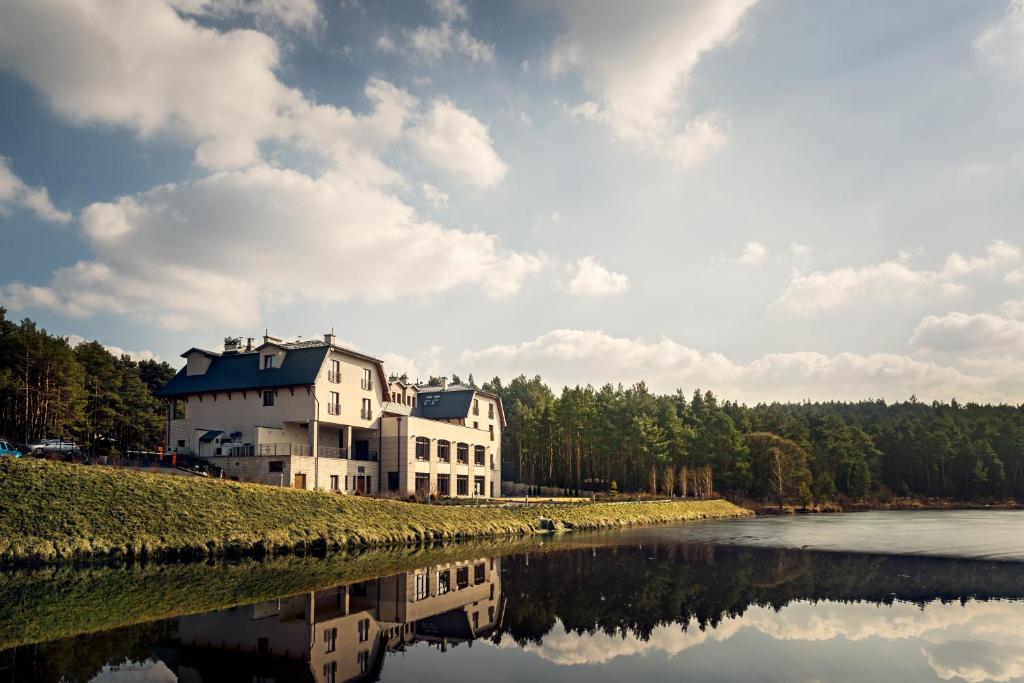 um grande edifício branco sentado ao lado de um rio em Hotel Natura Residence Business&SPA em Siewierz