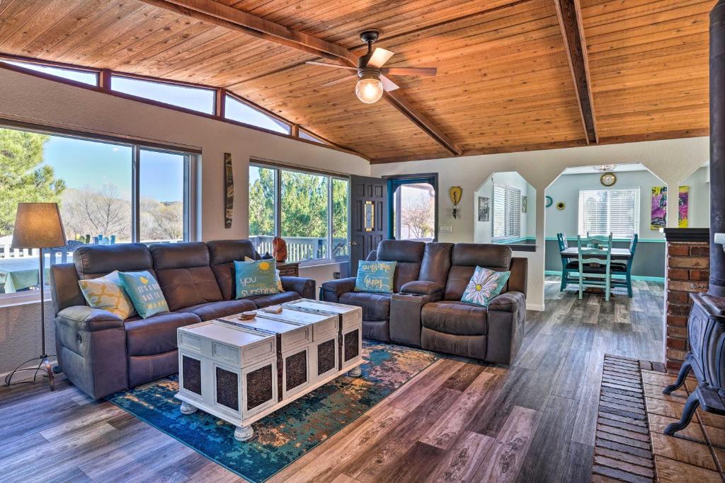 a living room with leather furniture and a ceiling fan at Colorful Cottonwood Home Walk to Verde River! in Cottonwood