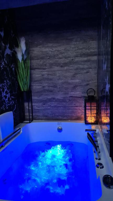 eine Badewanne mit blauem Wasser im Bad in der Unterkunft De LUX Apartman in Čačak