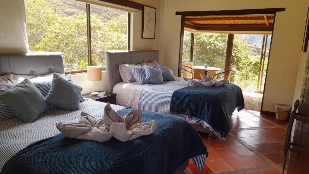 a bedroom with two beds with towels on them at Hotel Suamena in Ráquira