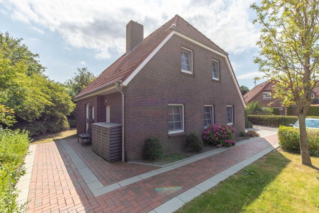 a small brick house with a brick driveway at Ferienwohnung Watt und Weite in Carolinensiel