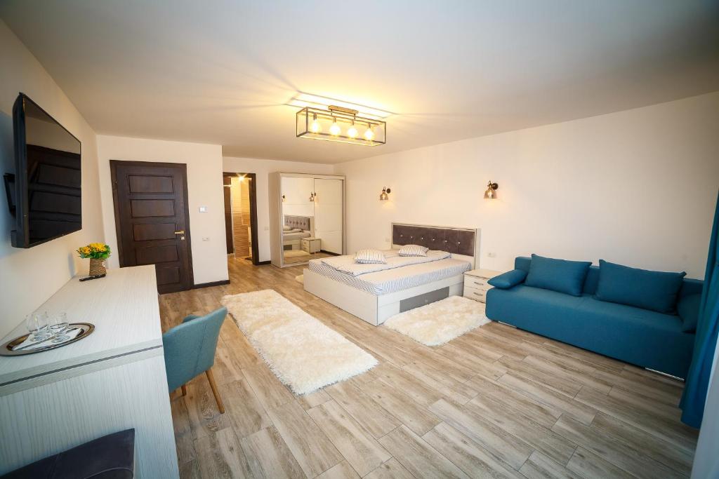 ROMANTIK RESORT في كامبولونغ مولدوفينيسك: غرفة معيشة مع سرير وأريكة زرقاء