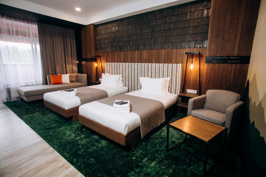 a hotel room with two beds and a chair at MORVA Premium Spa Resort in Yaremche