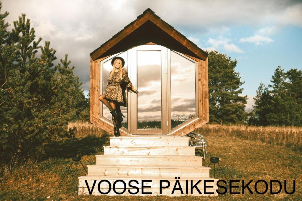 a woman is standing in a tiny house on some stairs at Voose Päikesekodu in Vose