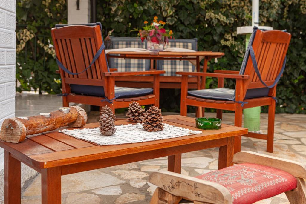 uma mesa de madeira com 2 cadeiras e uma mesa com pinhos em Vasiliki Cottages Agios Gordios em Agios Gordios