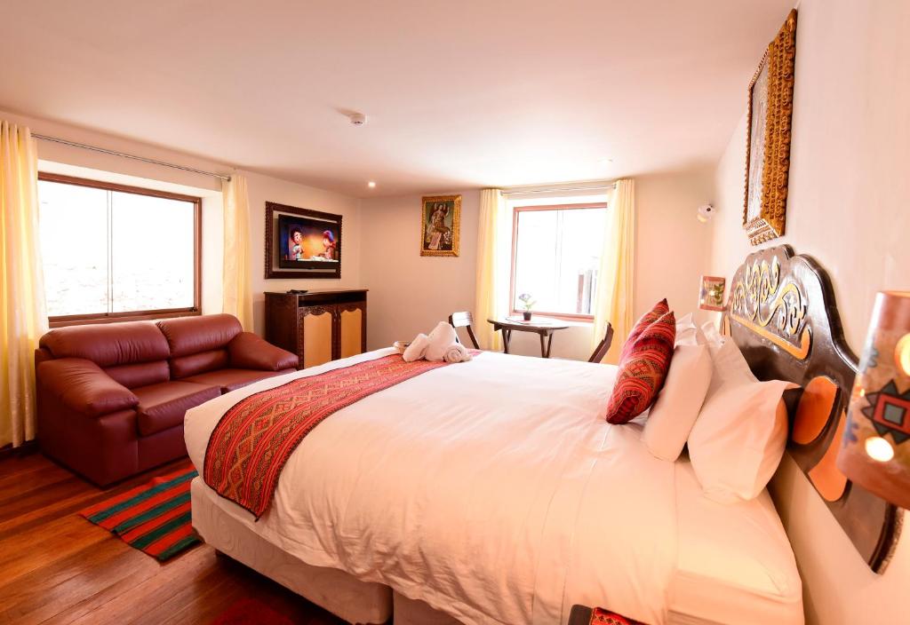 - une chambre avec un grand lit et un canapé dans l'établissement Hotel Boutique Gold Garden, à Cusco