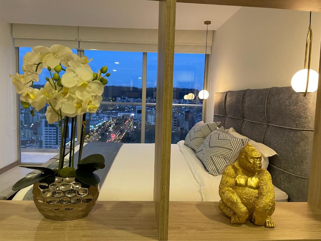 una habitación con un jarrón de flores sobre una mesa en NUEVA Suite-Piso 21 Vista La Carolina @ONE Quito, en Quito