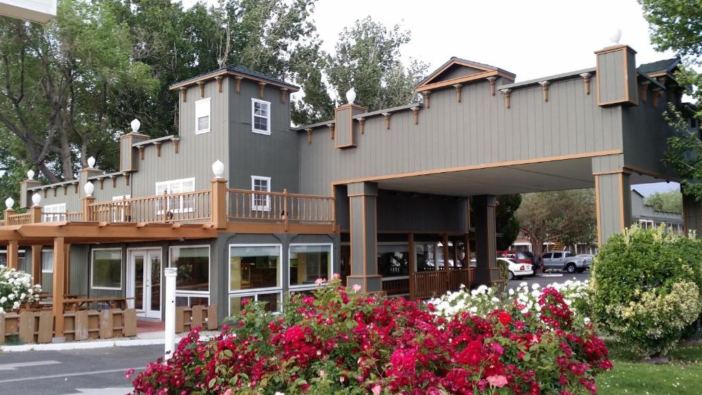 a large building with a balcony and flowers at Vagabond Inn Bishop in Bishop