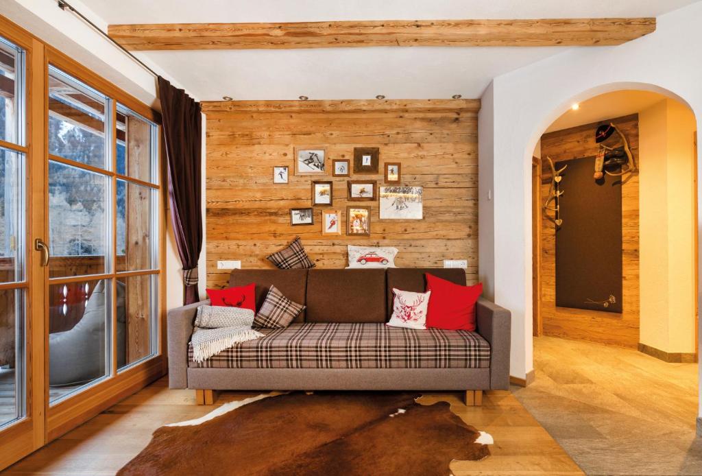 un soggiorno con divano e cuscini rossi di Naturapartments Schönfeld a Sesto